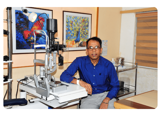 Dr. Parthopratim Dutta Majumder, Secretary of the Uveitis Society of India (USI) and Senior Consultant at Sankara Nethralaya, Chennai, pictured in a clinical examination room with a slit lamp biomicroscope used for diagnosing uveitis and retinal disorders. As the Founder of eOphtha and Head of Innovation, he specializes in ocular inflammatory diseases and medical retina.